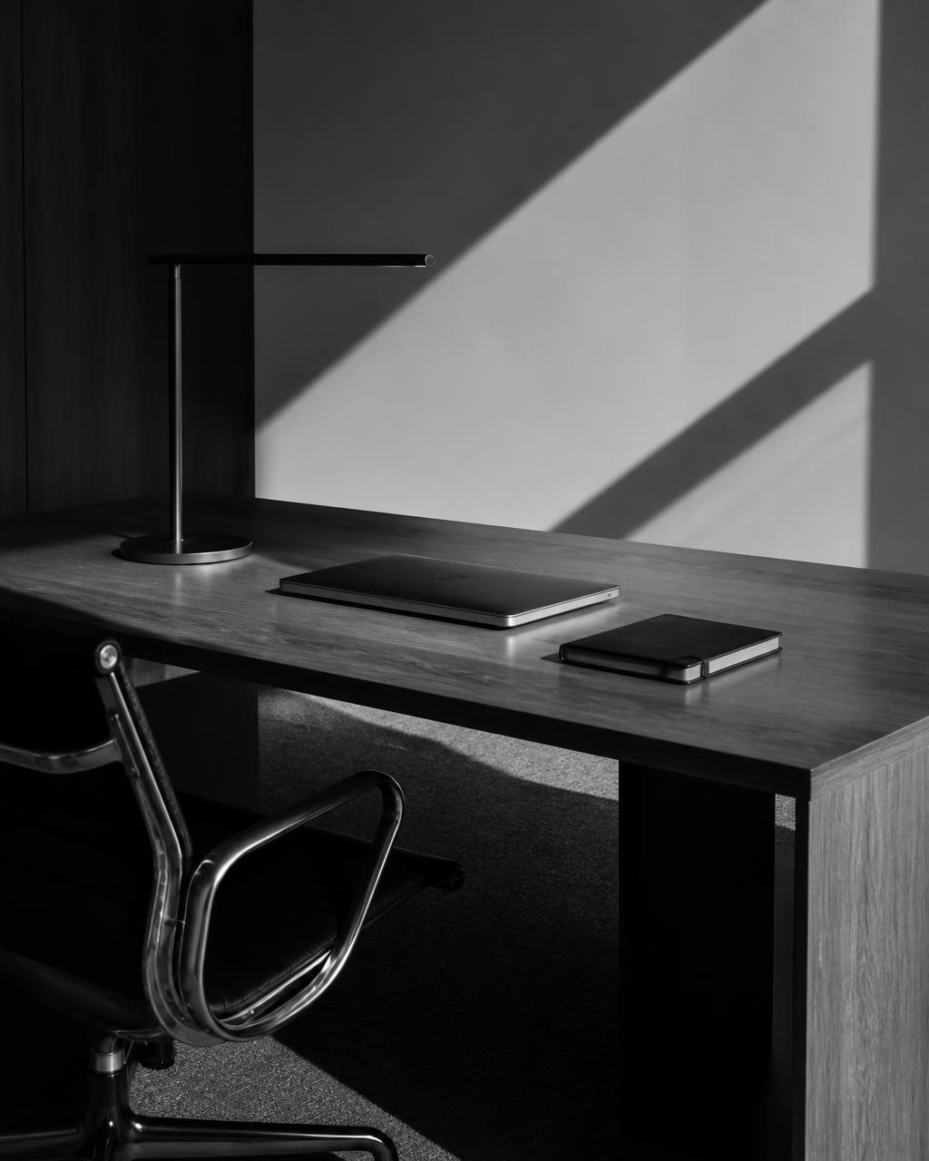 Minimal black and white office with a desk overlooking Thessaloniki